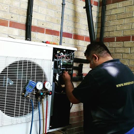 Illustrative technician checking a condenser with pressure gauges